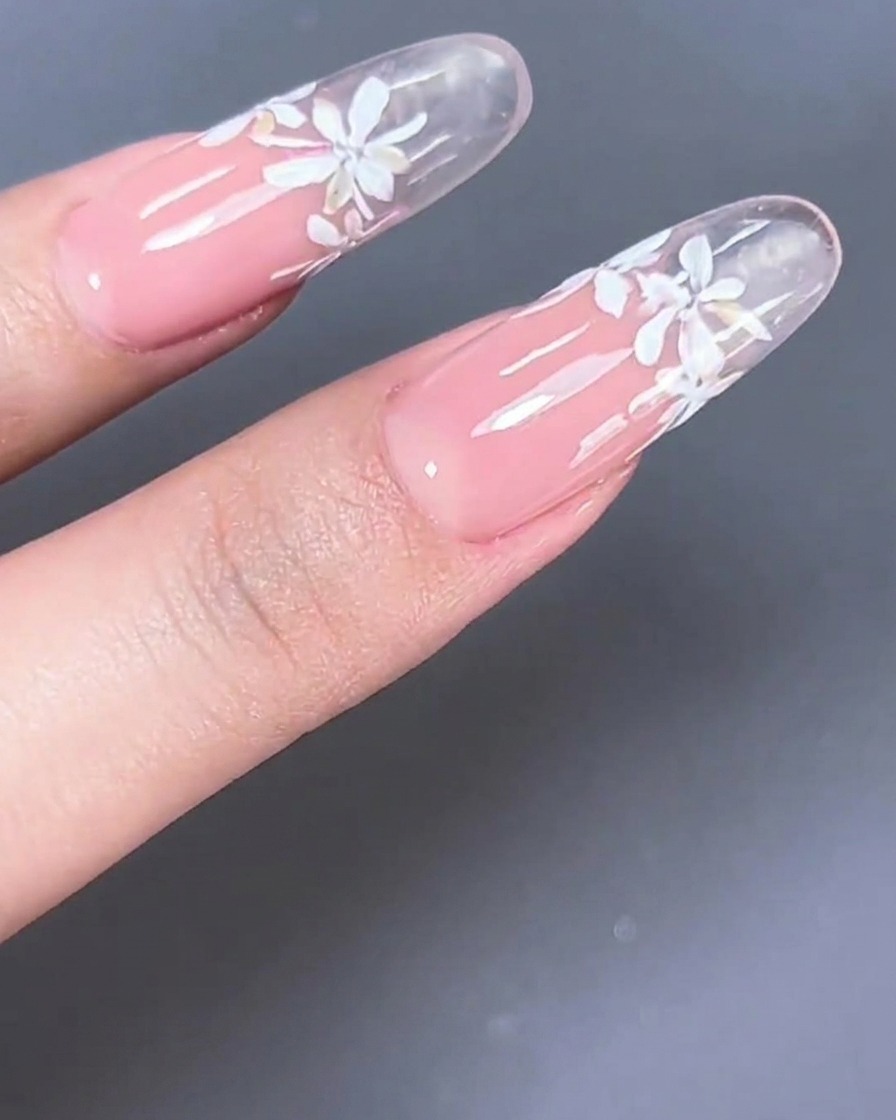 A clear nail tip showing milky pink gel applied to the nail bed area.