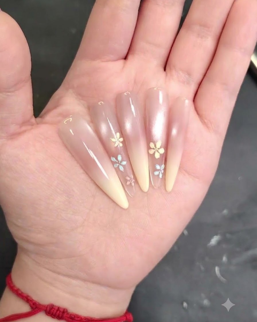 A nail brush blending and smoothing pink blush gel evenly across the nail surface.