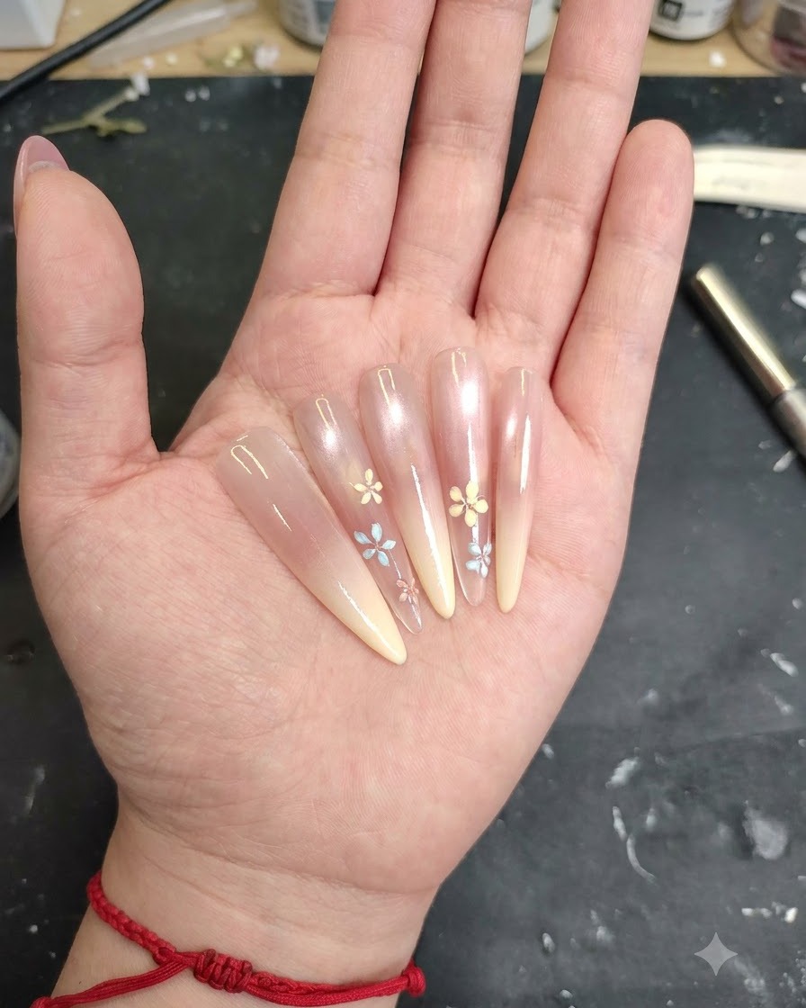 A brush applying a clear gel base coat over the nail surface.