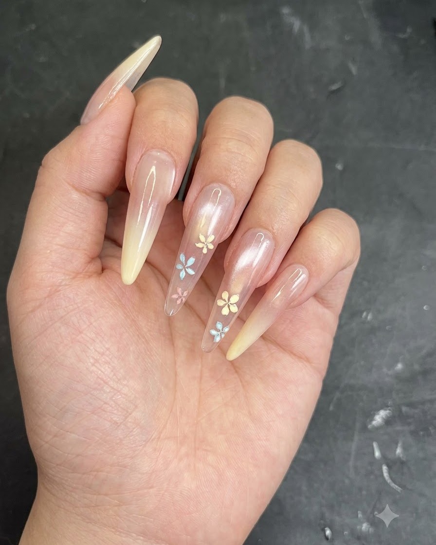 A brush or sponge tapping creamy yellow gel onto the tip of a clear almond-shaped nail to form an ombre gradient.