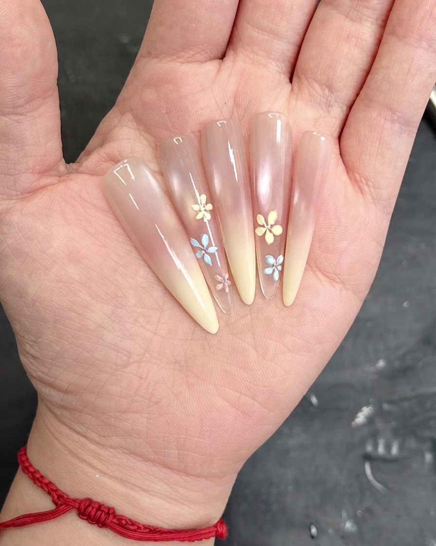 A brush applying a clear top coat layer over the decorated nail surface.