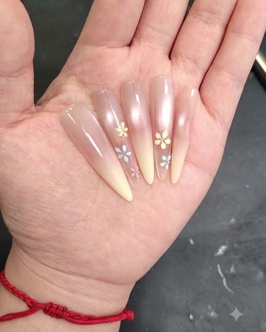 A detailed shot of a nail art brush applying a small petal detail to a painted nail.