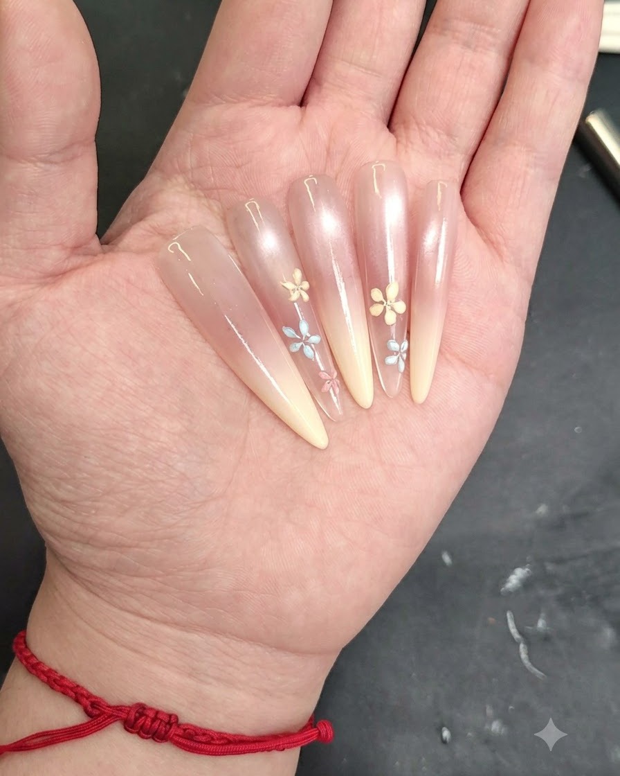 A close-up of a nail showing additional petals being drawn to finish a small flower design.