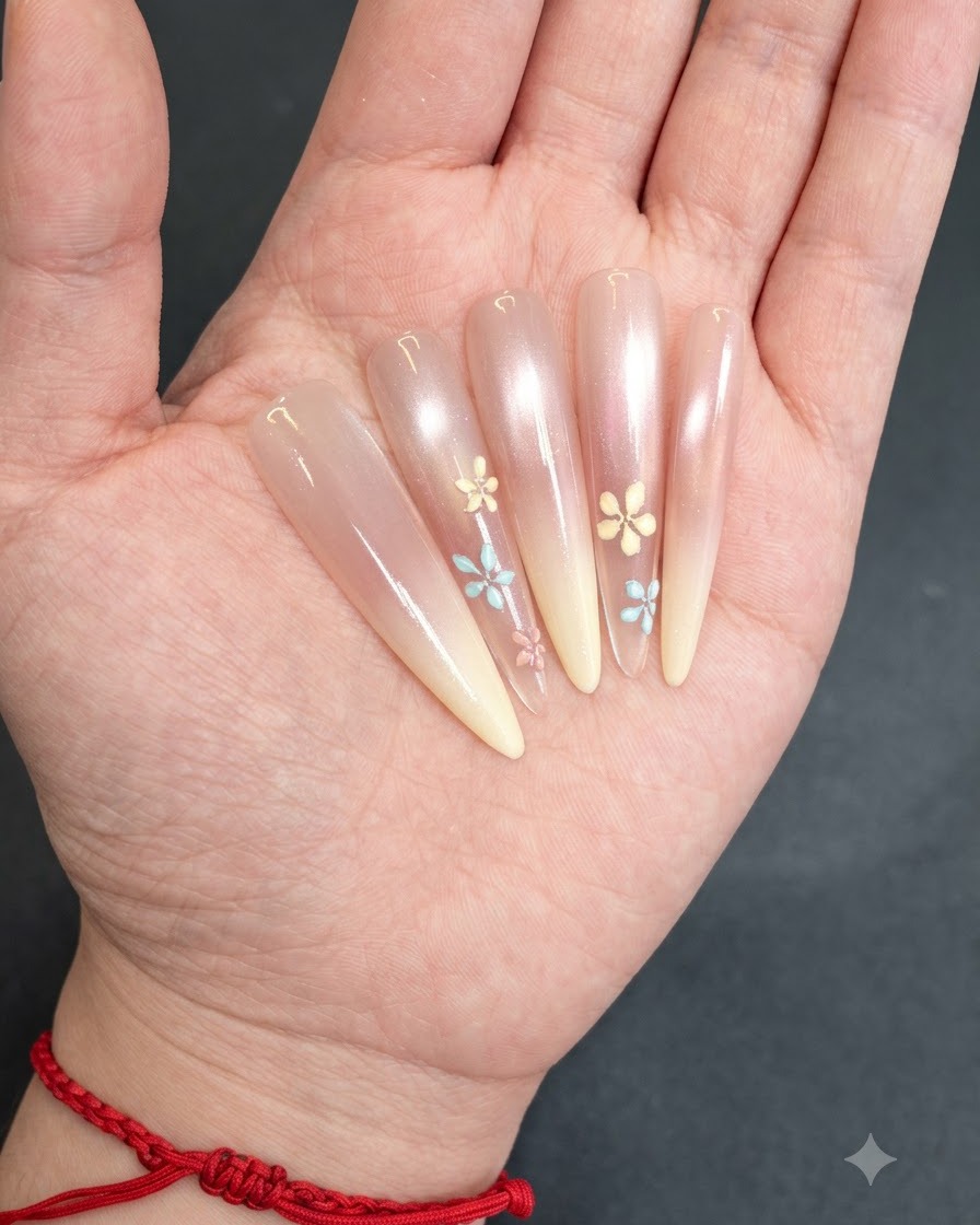 Nails with hand-painted floral designs curing under a lamp.