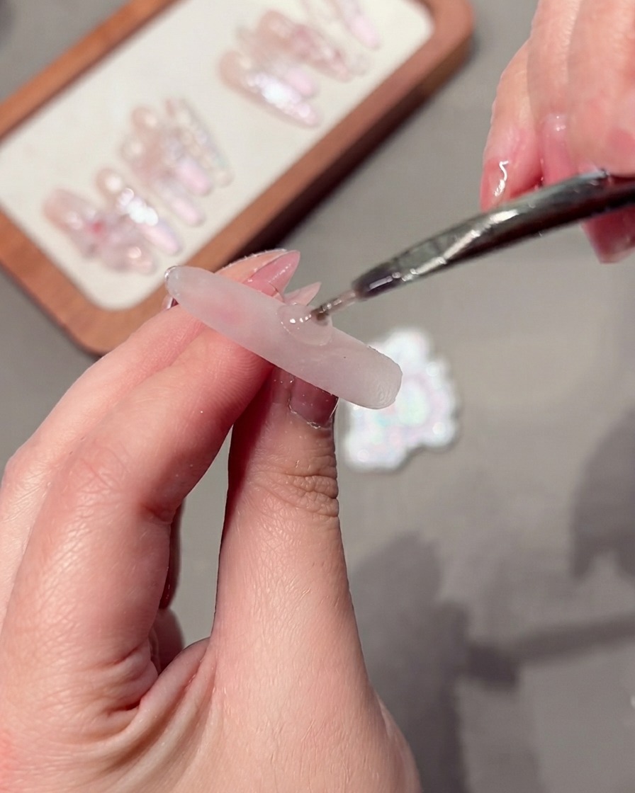 A tool being used to manipulate cat-eye gel particles on a nail.