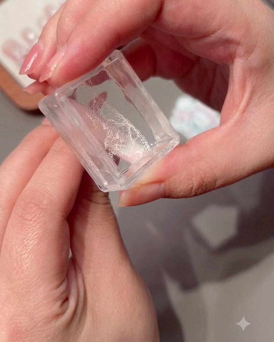 A clear stamper holding a transferred lace pattern.