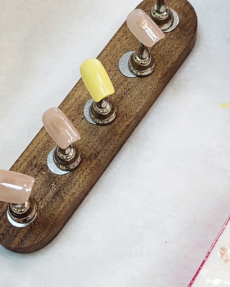 Nail tips with base colors applied, ready for curing.