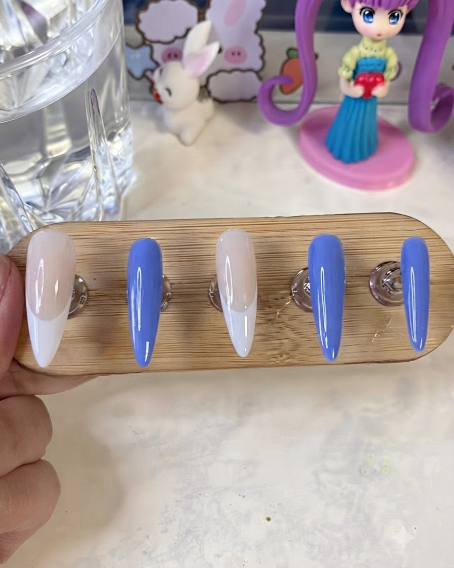 Nail stands with finished painted nails sitting under a UV/LED curing lamp.
