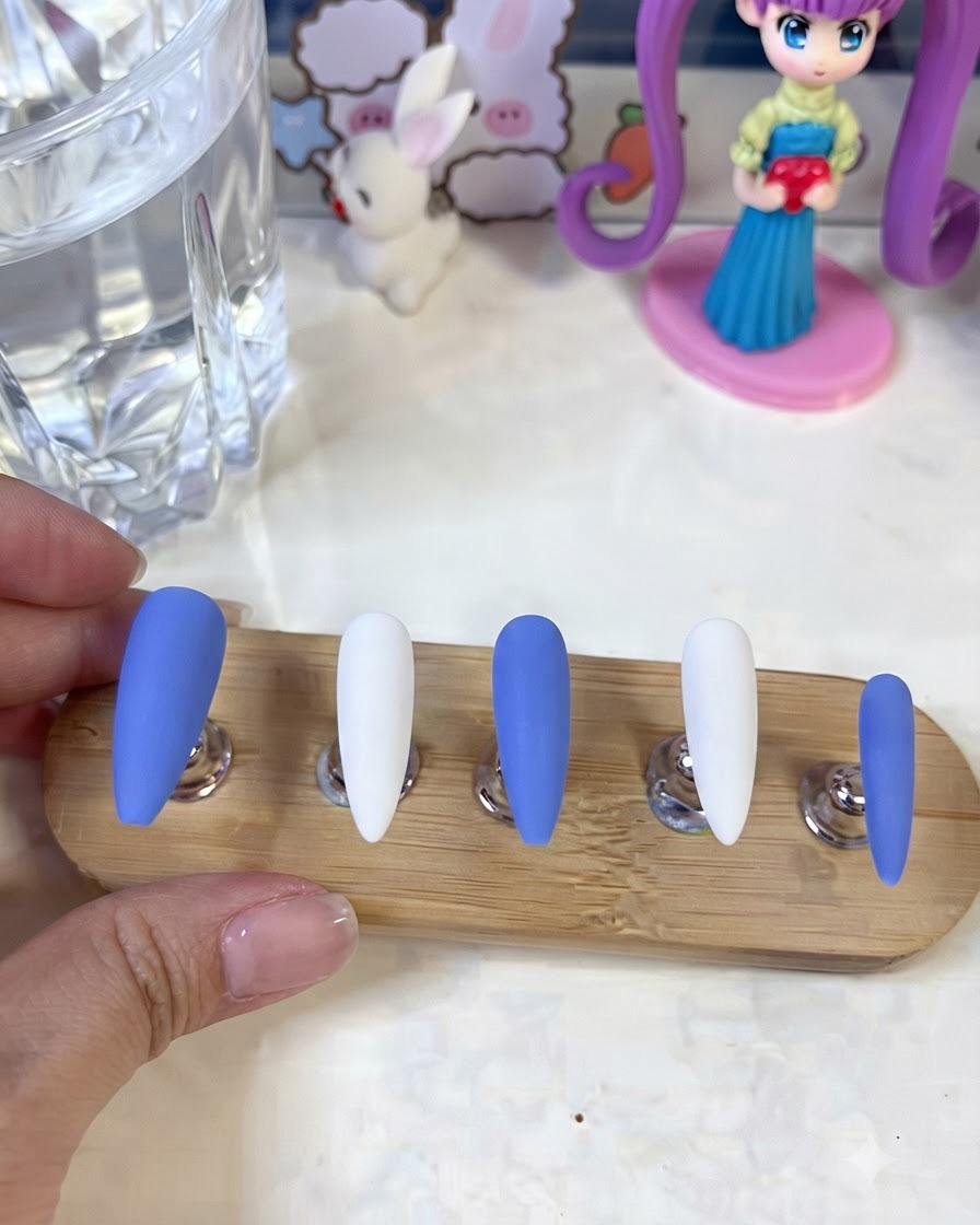 Nails displayed on a stand showing finished white gypsum flower and line art details.