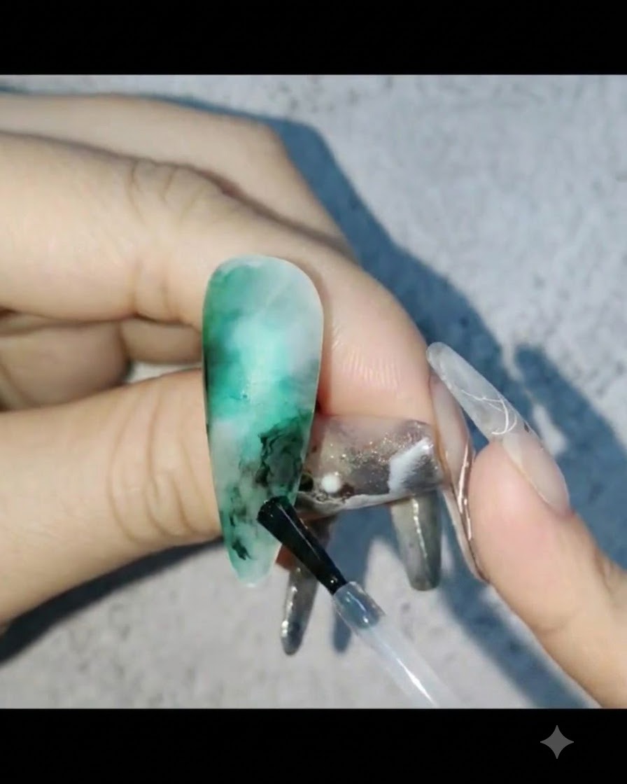 Applying milky white gel into the empty areas of the nail design and blending it out.