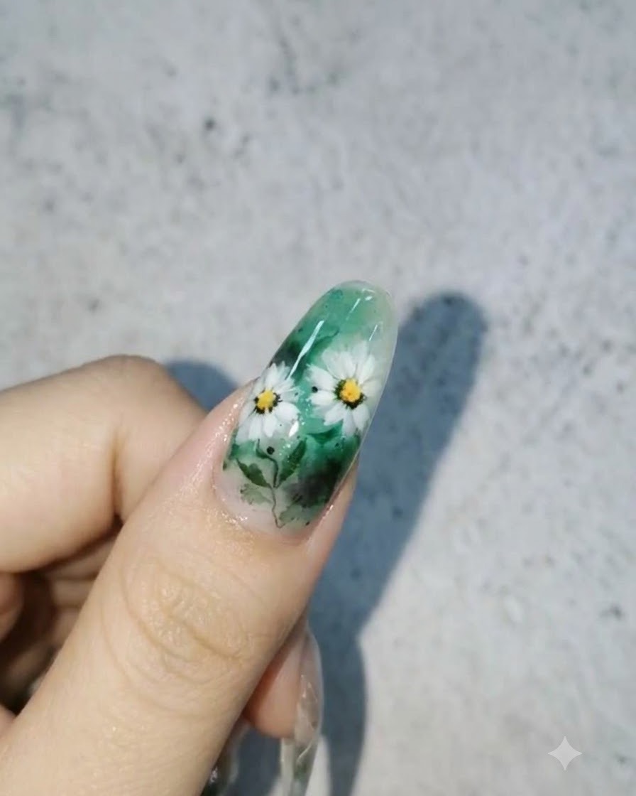 A finished nail design featuring white daisies and leaves on a green background with glossy 3D water droplets on the surface.