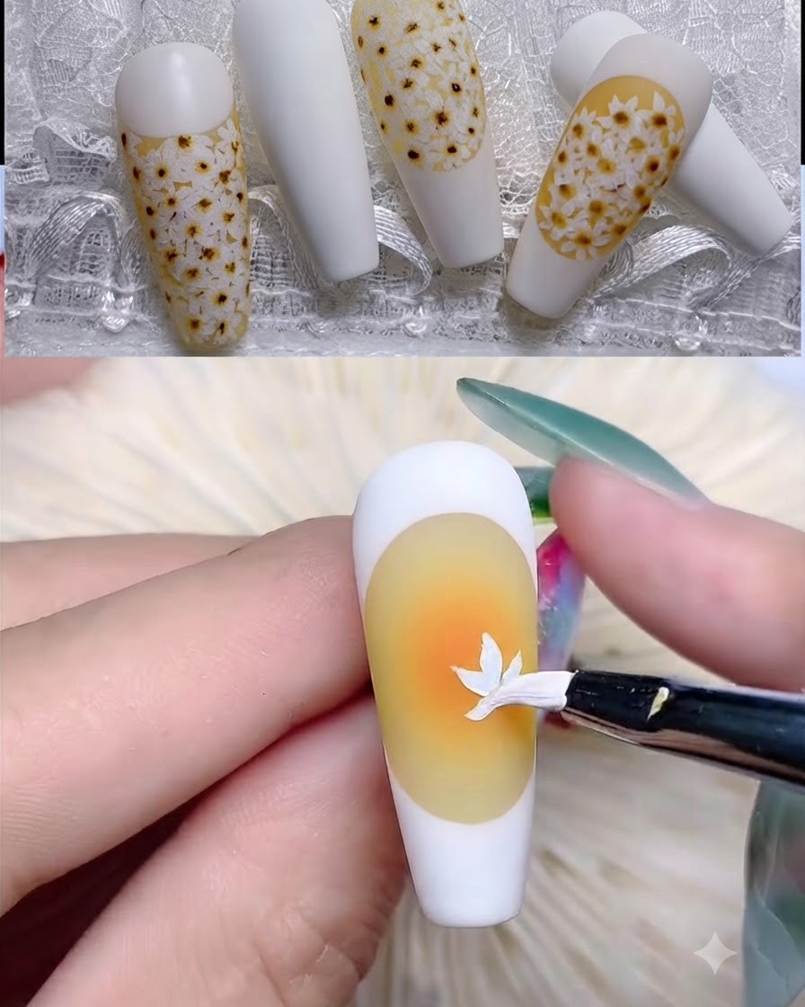 A fine liner brush drawing a white French tip border on a yellow-based nail.