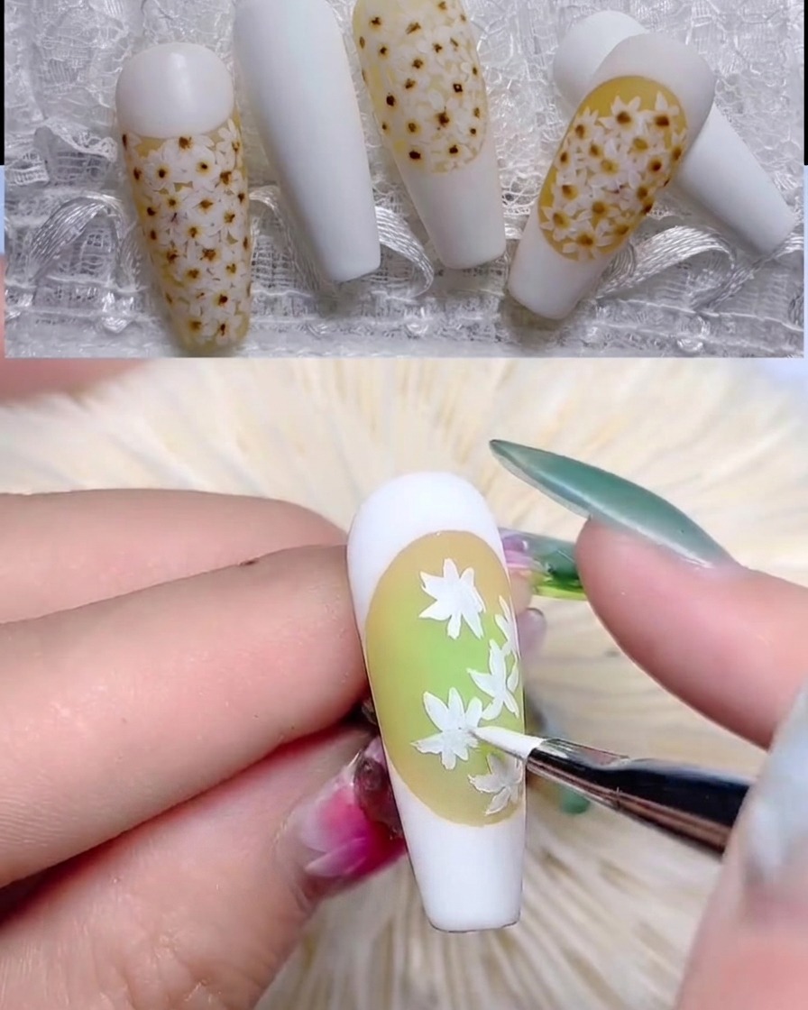 A fine brush adding detailed white petals to complete the first daisy layer.