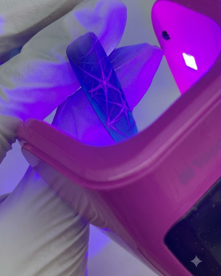 A close-up shot showing white dots being applied and patted out into a halo effect on the nail.