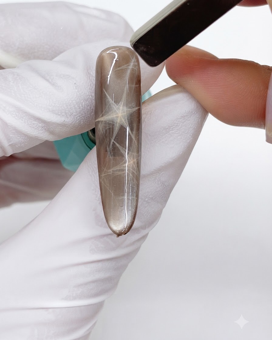 A rectangular bar magnet hovering over the nail, pushing a second layer of magnetic shimmer into an opposing triangle.