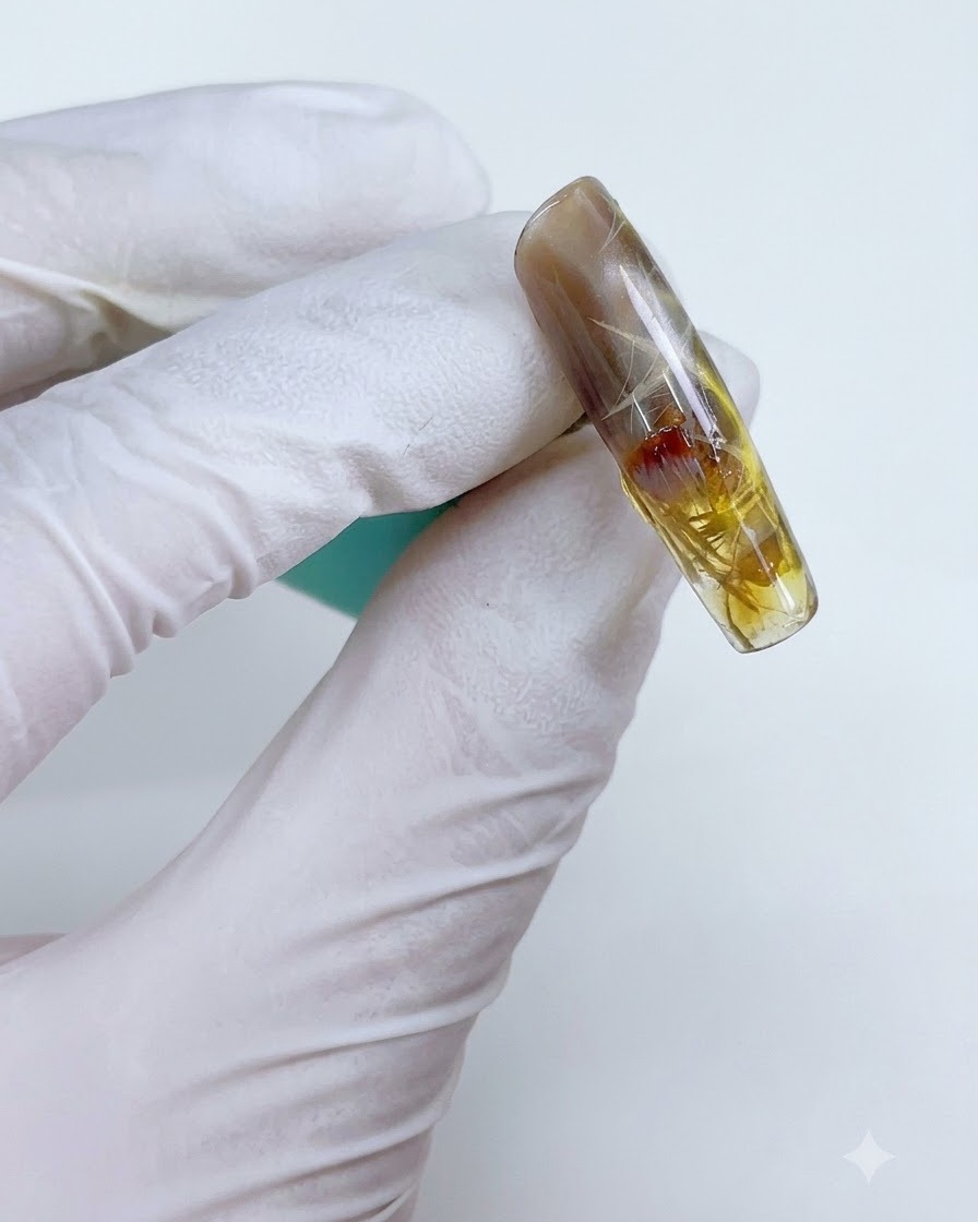 A nail with sheer yellow-brown gel selectively applied over the starlight design.