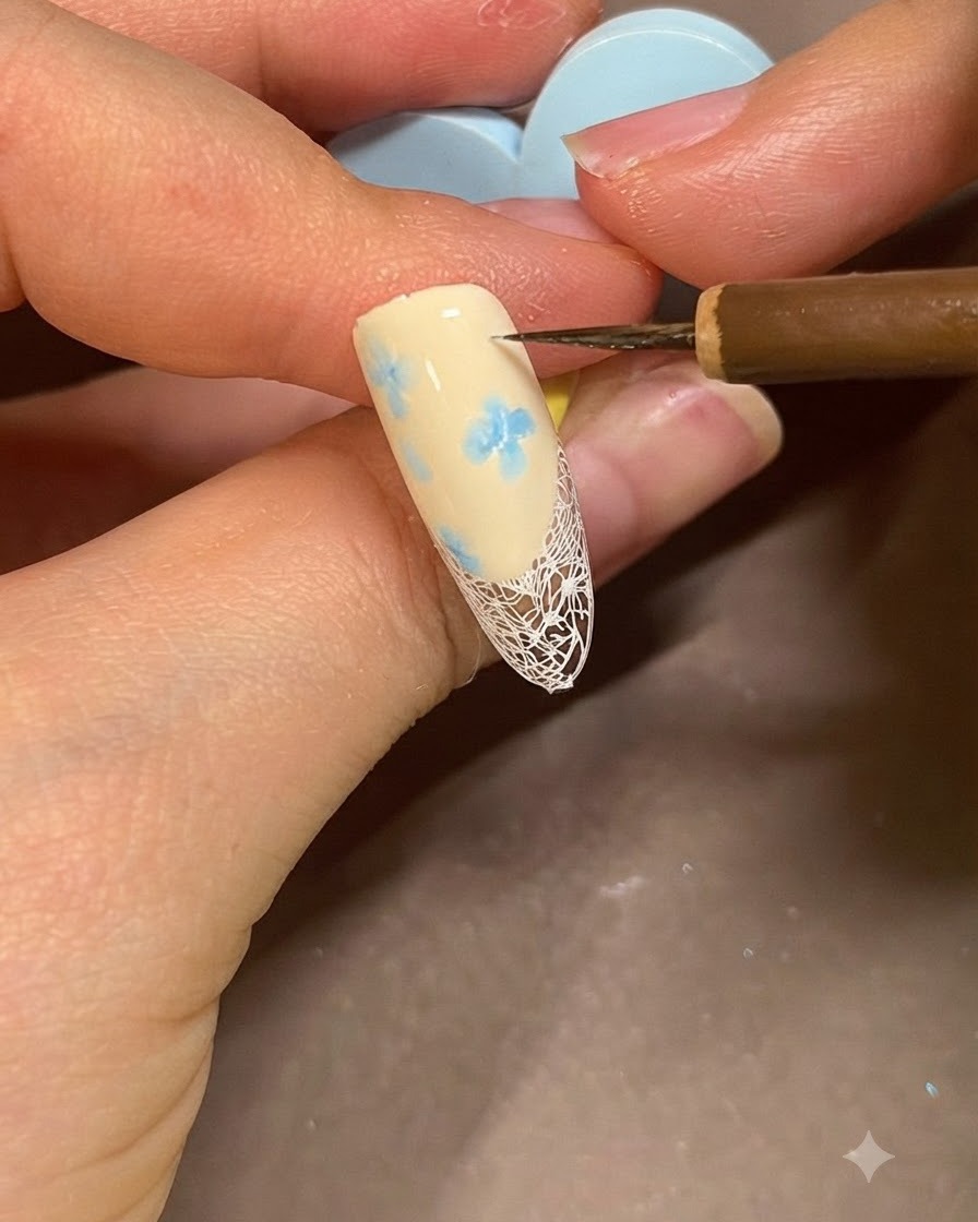 A brush applying clear builder gel over a decorated nail to smooth and protect the design.