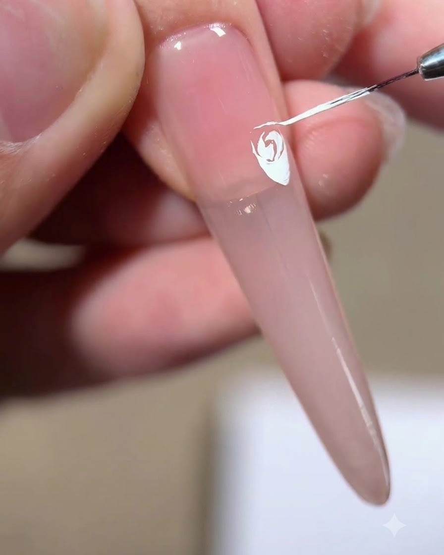 A liner brush drawing an inverted white triangle to position the fourth petal.
