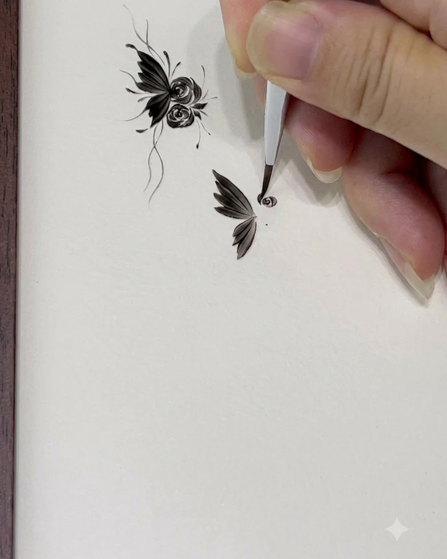 A fine tip brush drawing a small 6 shaped outline to start the center of a rose.