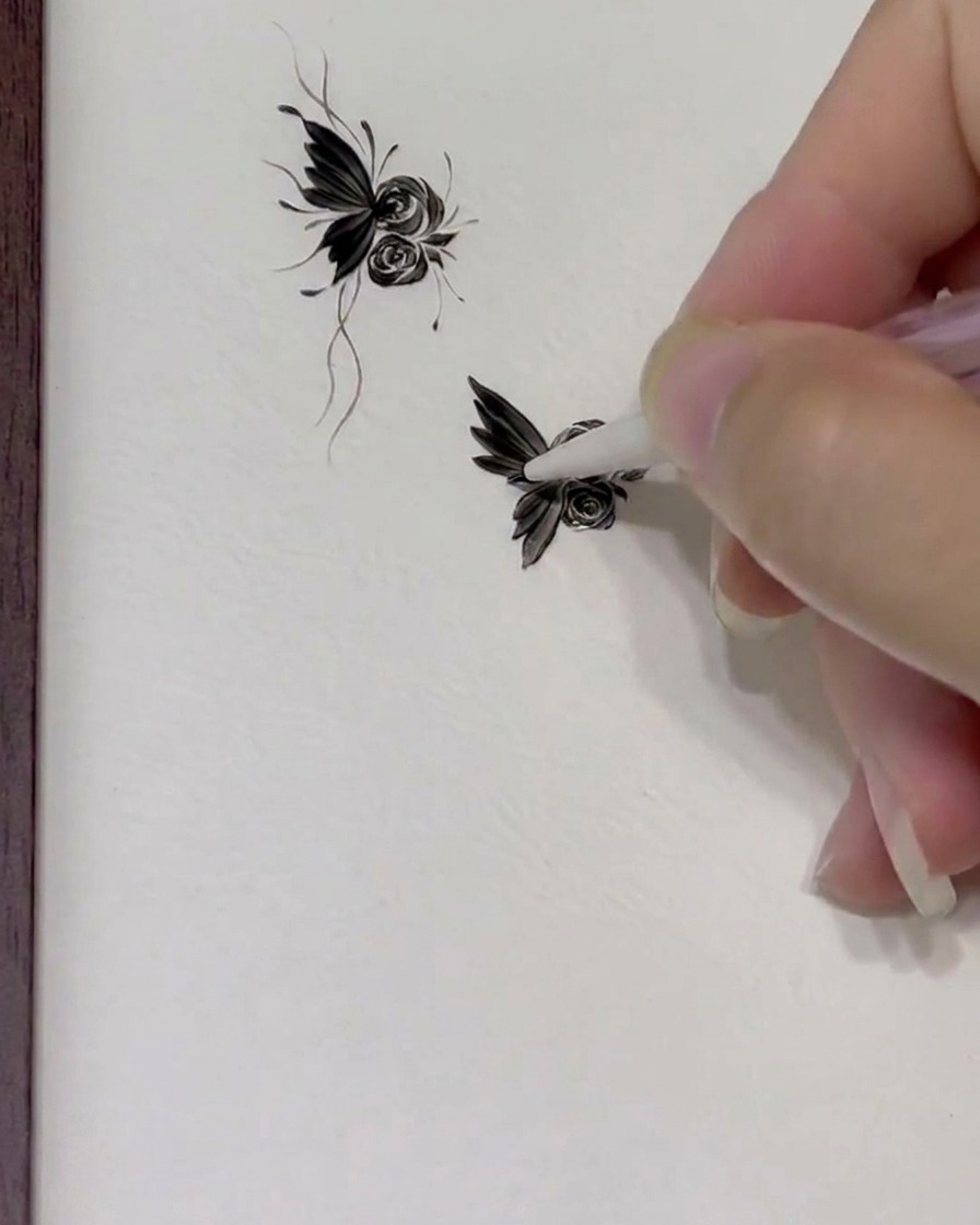 A close-up view of a nail art brush applying precise gel dots and clean fine lines onto a floral butterfly design.