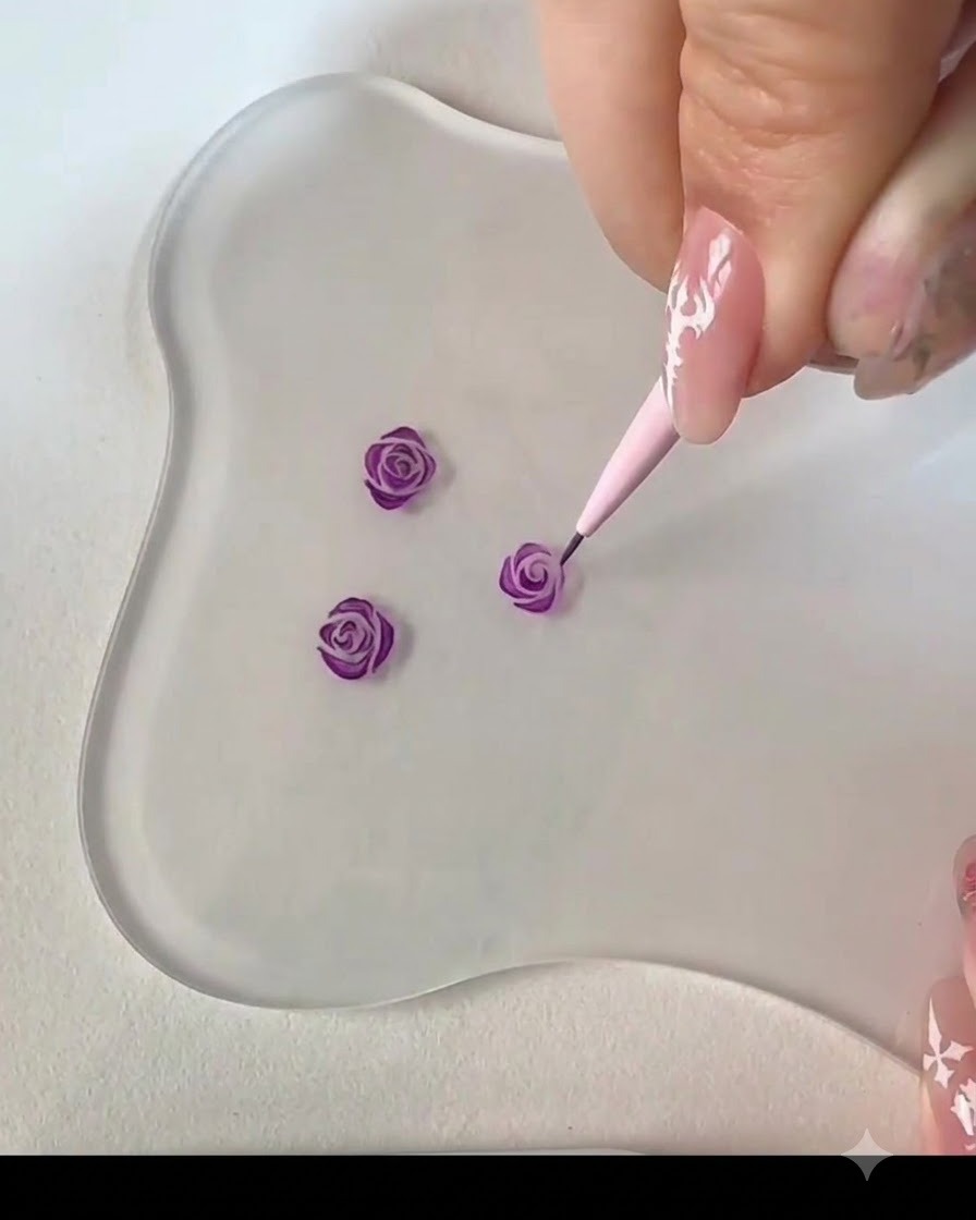 A fine liner brush adding an adjacent curved stroke to complete the center of the purple rose bud.