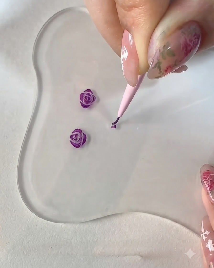 A fine liner brush placing a tiny standalone dot stroke next to the forming center of the rose.