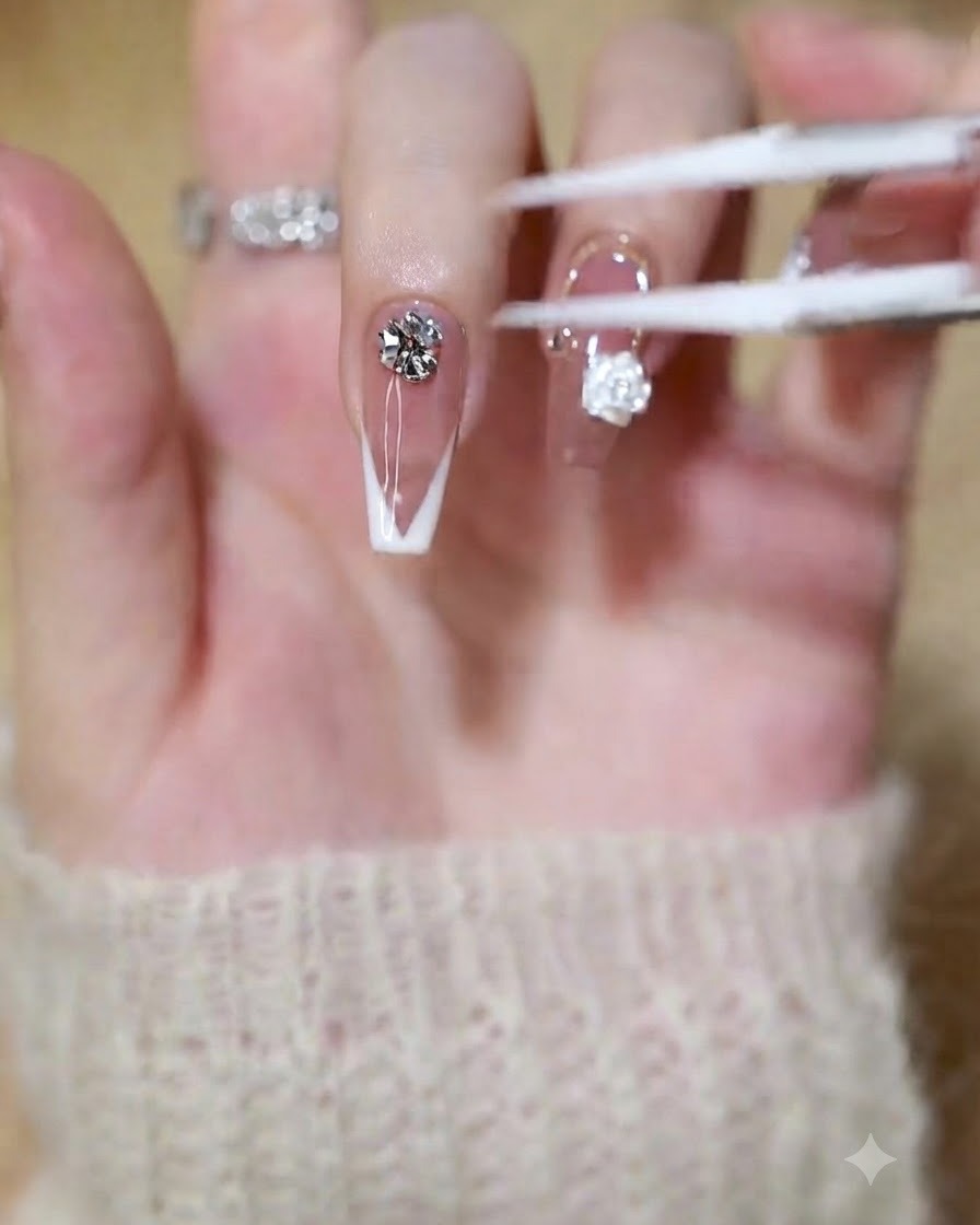 A brush or tool applying clear builder gel onto the tip of a French manicure nail.