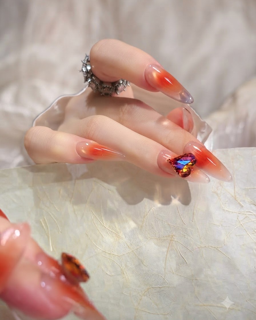 A close-up image of a thumb showcasing a long almond nail with an even, translucent orange jelly gradient.