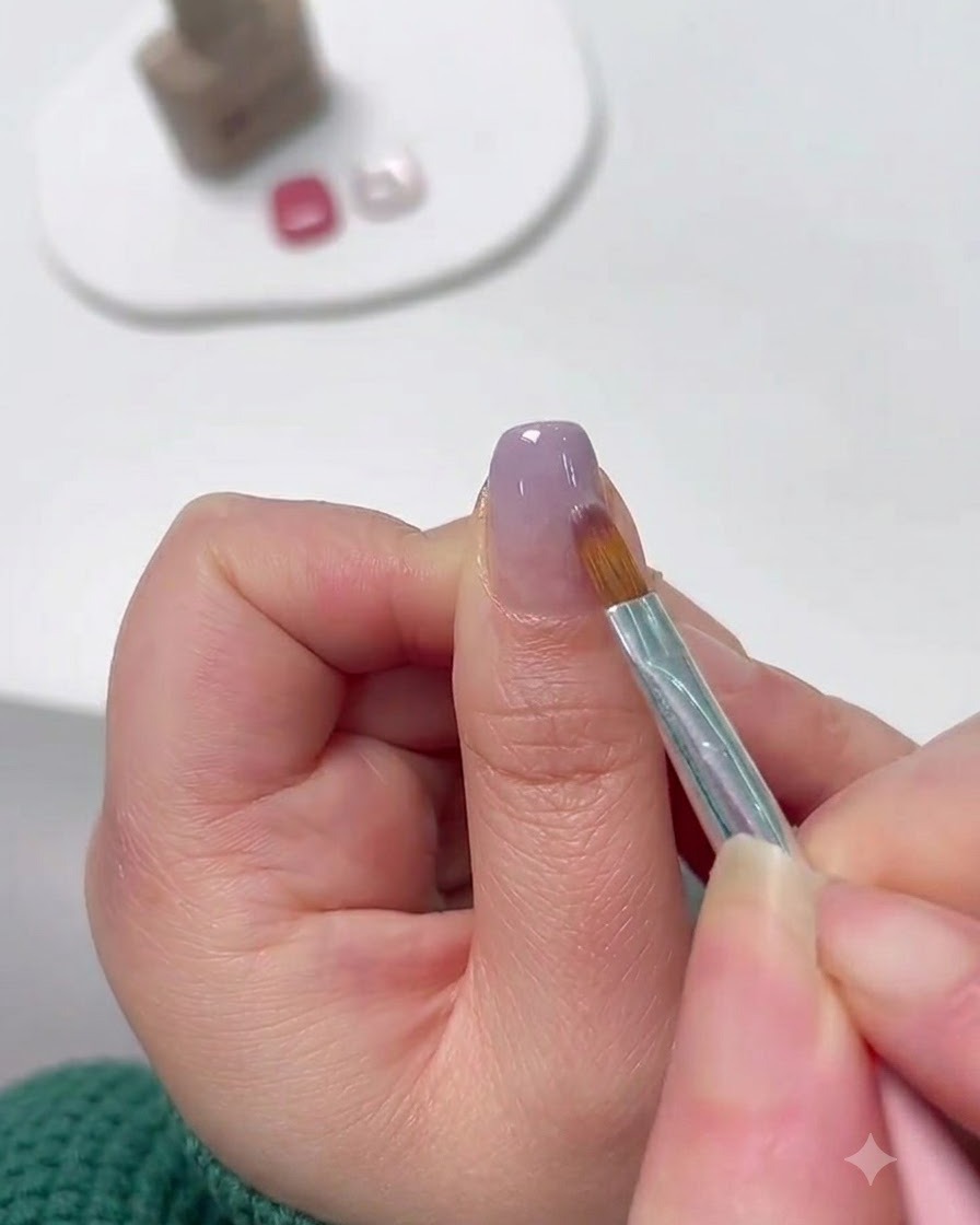 A fine detailing brush feathering lavender gel from the tip upward to form a gradient.