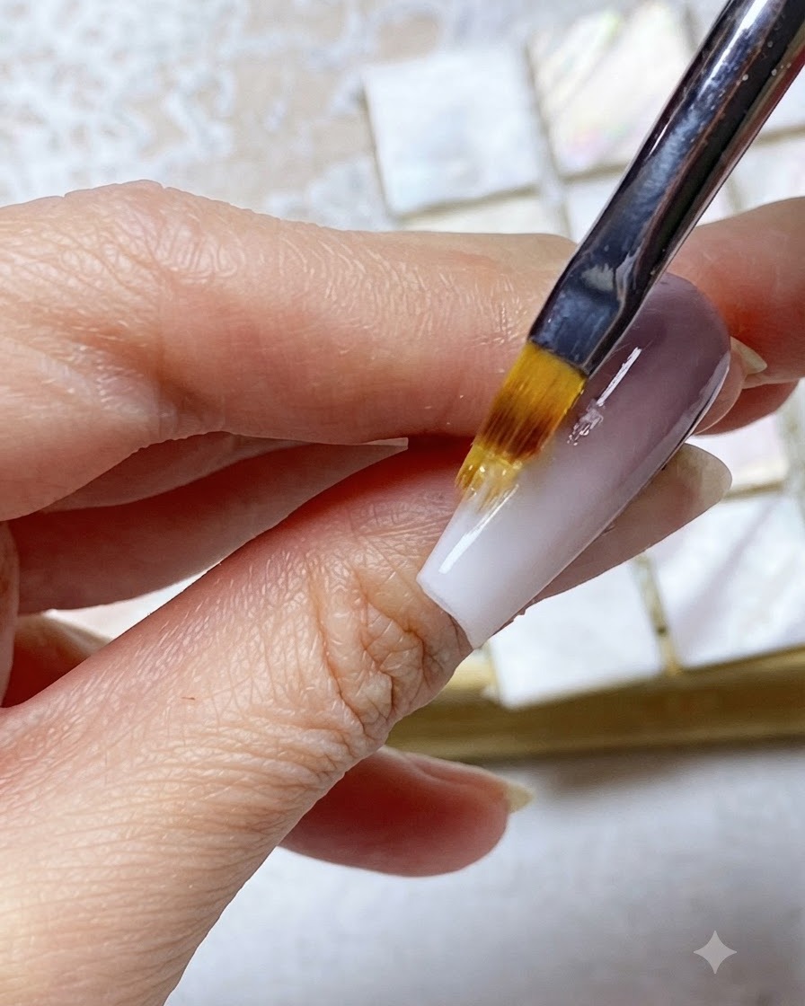 An ombre brush blending the white tip gel upwards into the purple upper nail section.