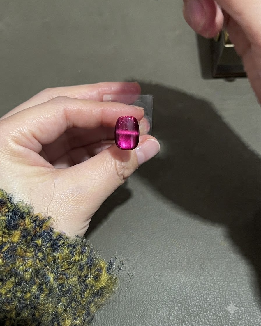 A magnet hovering over the nail, shaping a distinct horizontal light stripe across the middle.