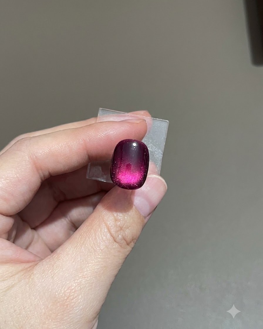 A close-up view of a purple frosted cat-eye nail allowing the matte top coat to level out.