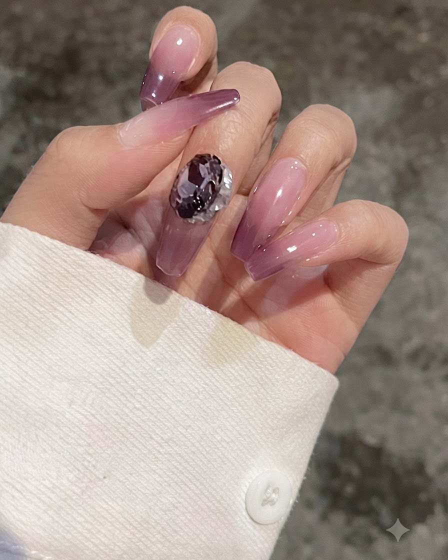 A close-up of a finger with a purple gradient nail showing a heart-shaped gem placed on it for comparison.