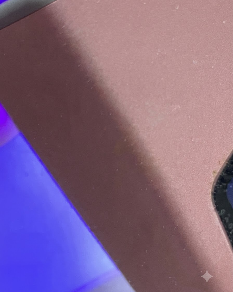 A finger placed beneath a purple-lit mini UV/LED lamp for curing.