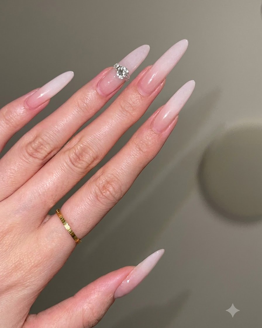 A nail technician using a brush in a gentle tapping motion to create a milky white ombre gradient on a nude base.