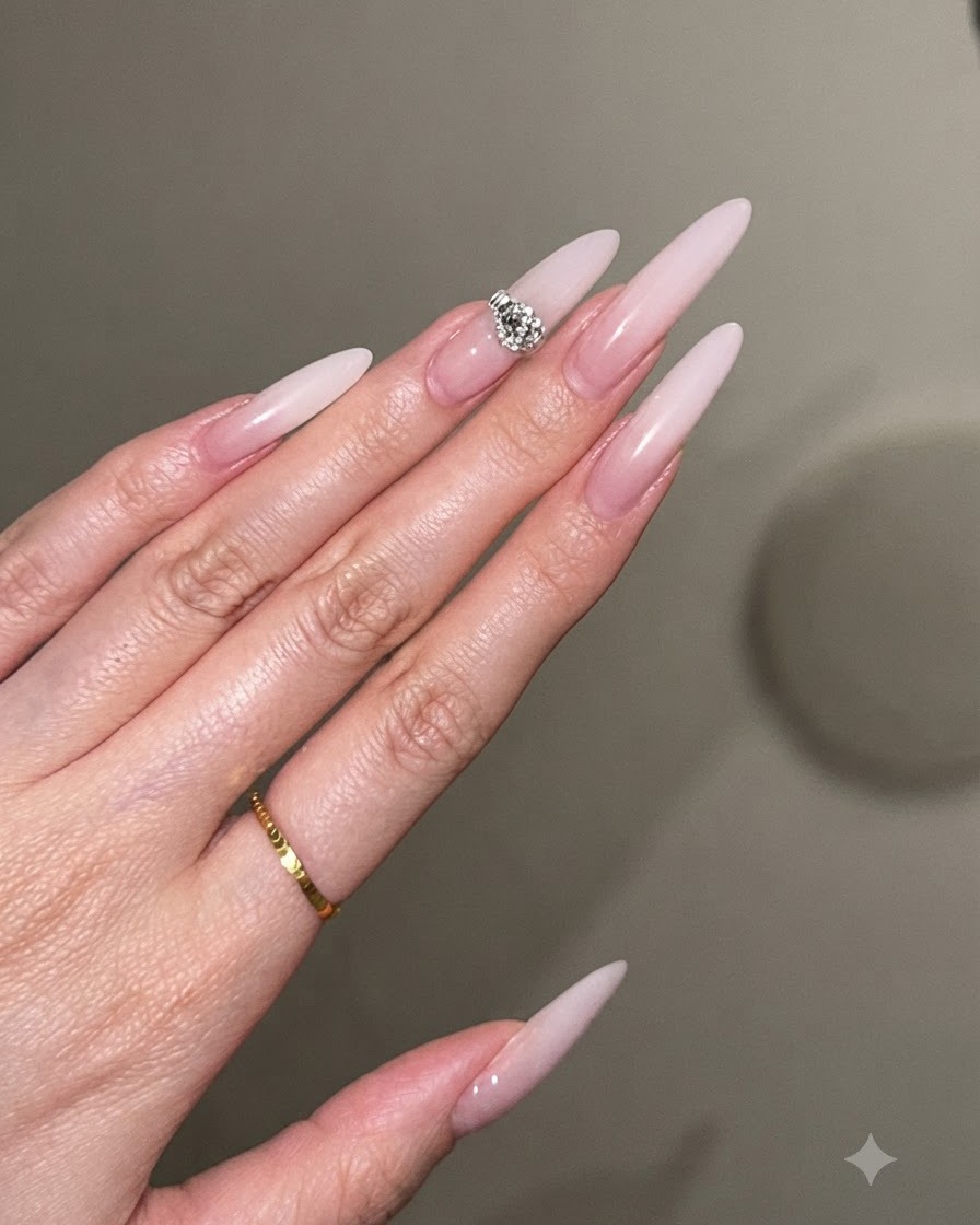 A close-up view of a nail brush applying a second layer of milky white gel to build tip opacity.
