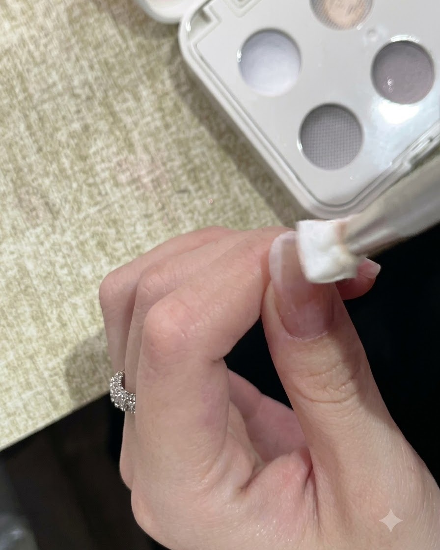 A sponge tool dabbing white solid clay gel onto the tip of a manicured fingernail.