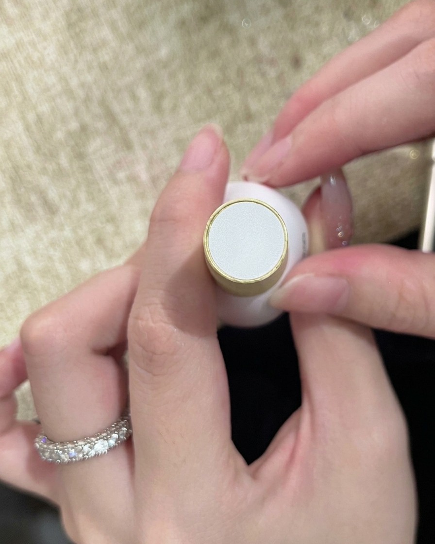 A bottle of clear top coat held in hand, ready to seal the finished nail art.
