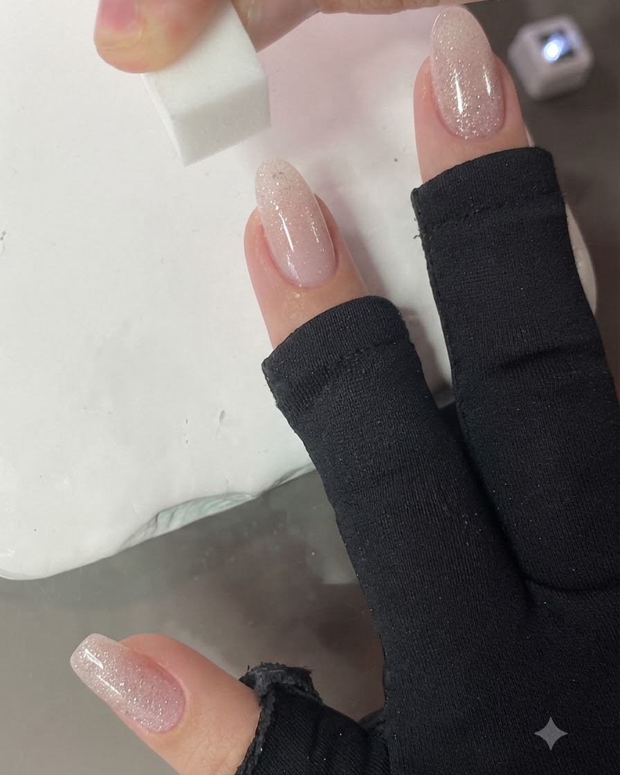 A small sponge dabbing vertically onto the nail to blend the nude pink gradient.
