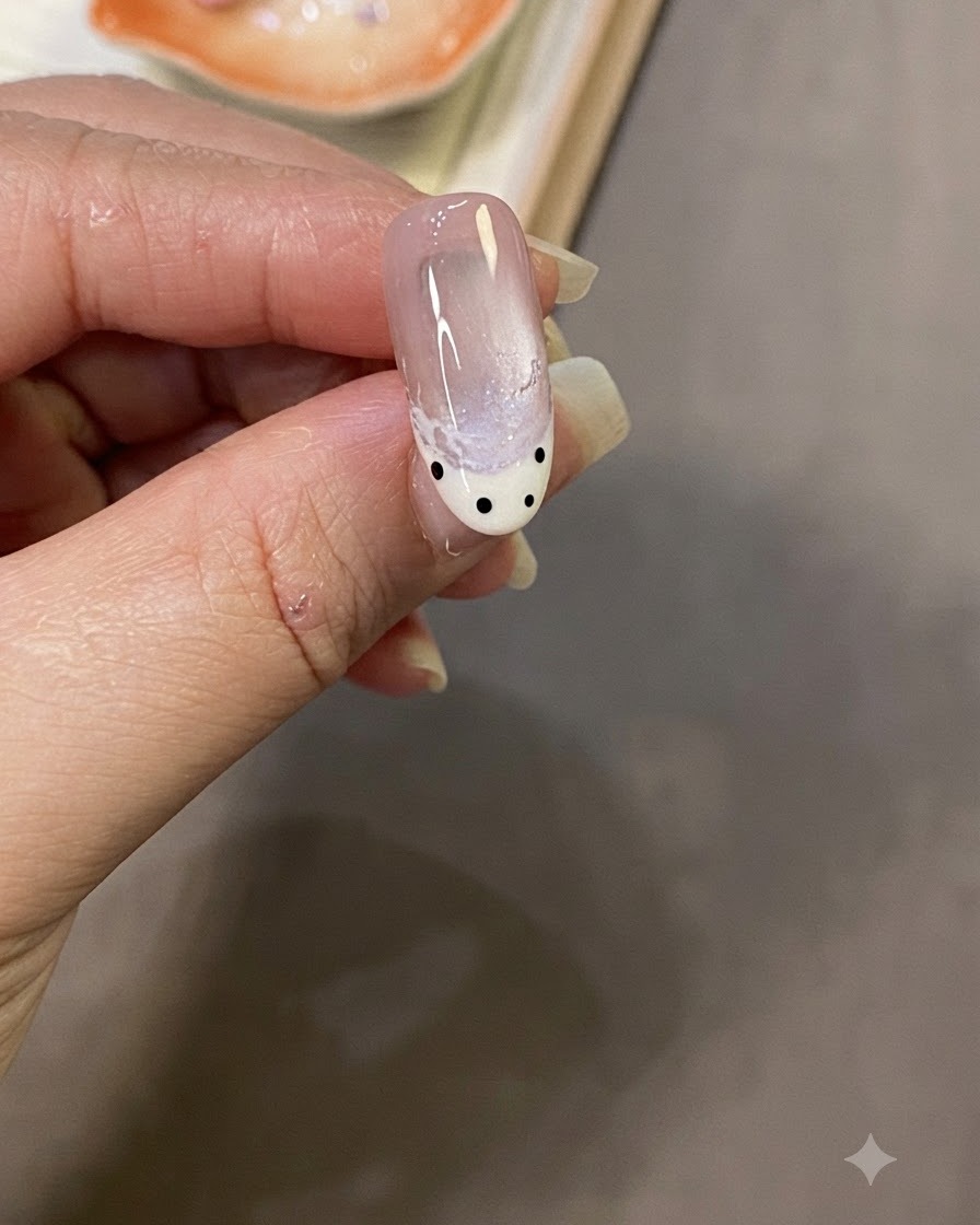 A close-up shot of a hand applying a final glossy top coat over the completed nail design.