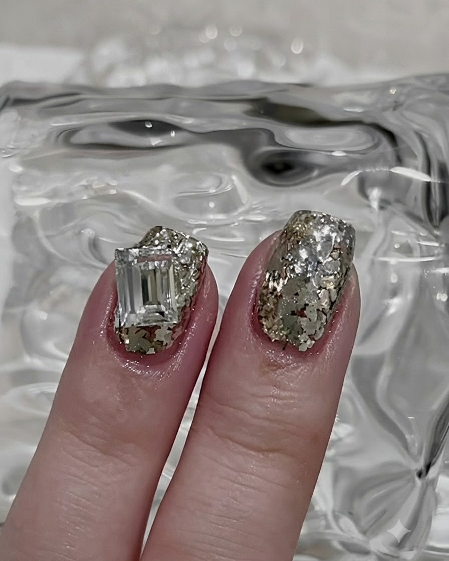 A thin nail art brush picking up a small portion of loose silver glitter powder.
