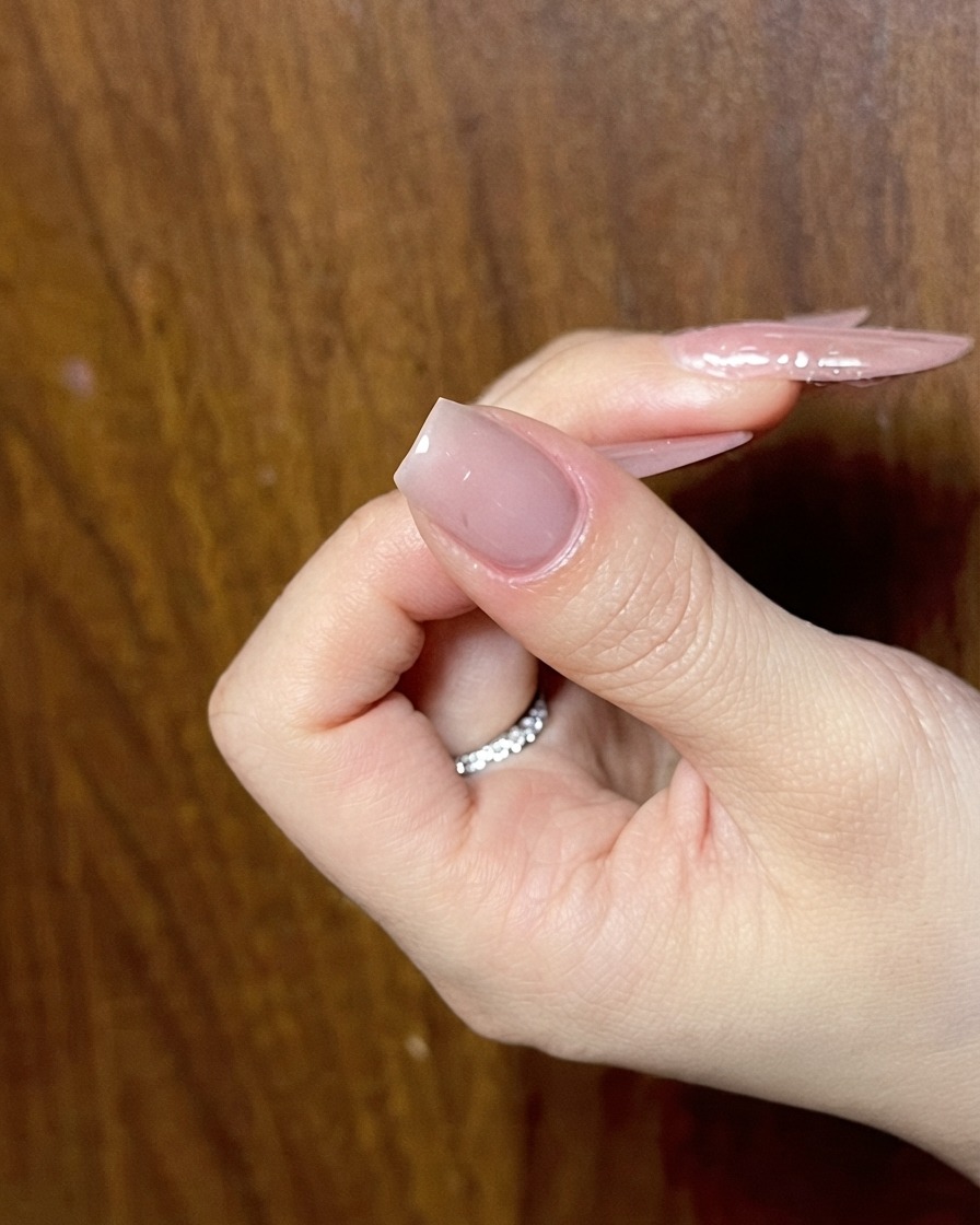 A hand showing a prepped nude nail ready for the next phase of detailed nail art.