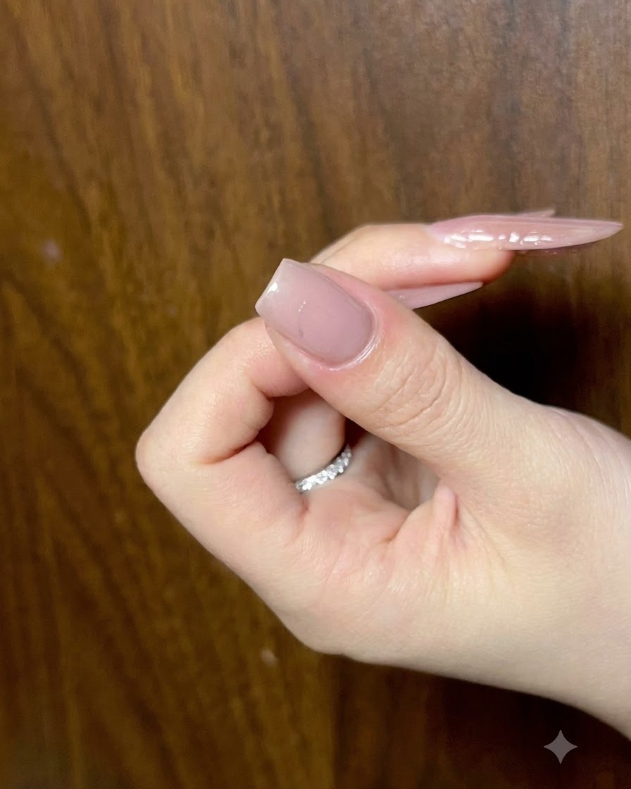 A close-up image showing a fingernail being cured under a lamp to set the center detail.