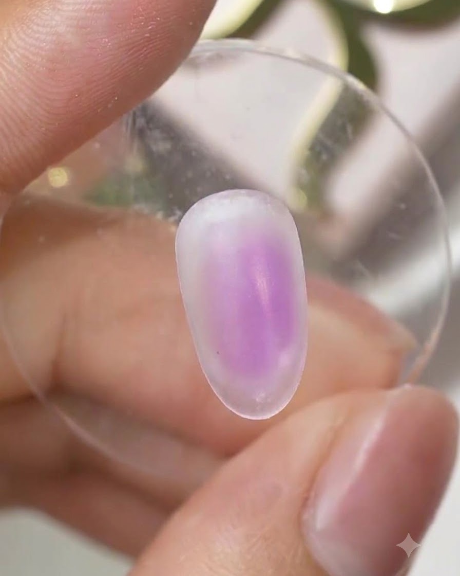 A cured nail surface showing a soft purple ombre gradient centered on the nail.