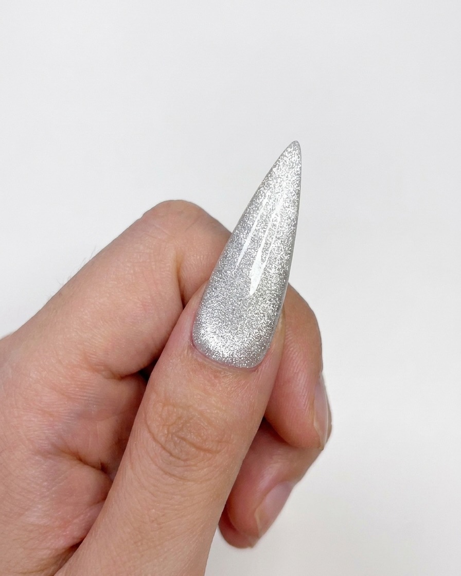 A completed cat-eye nail tip showing a cured, glossy finish with a centered highlight.