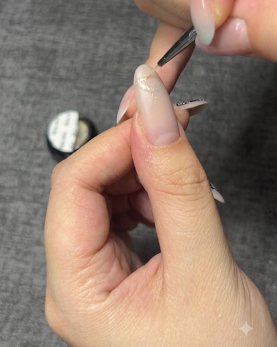 A close-up of a nail with a sparkle gel butterfly base outline.