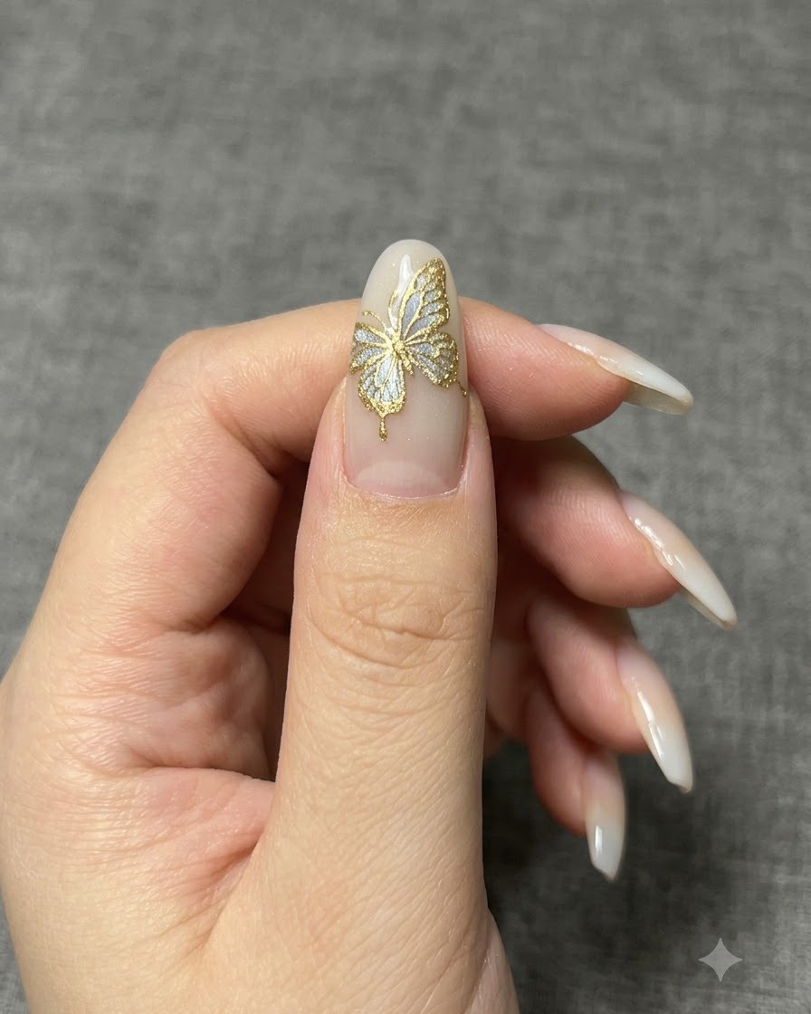 A close-up of a manicured nail showing a shimmering color-shift powder being applied over a base layer.