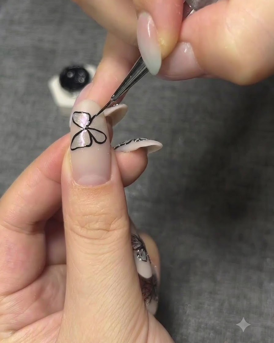A detailed shot adjusting the close alignment of butterfly wings painted on a fingernail.