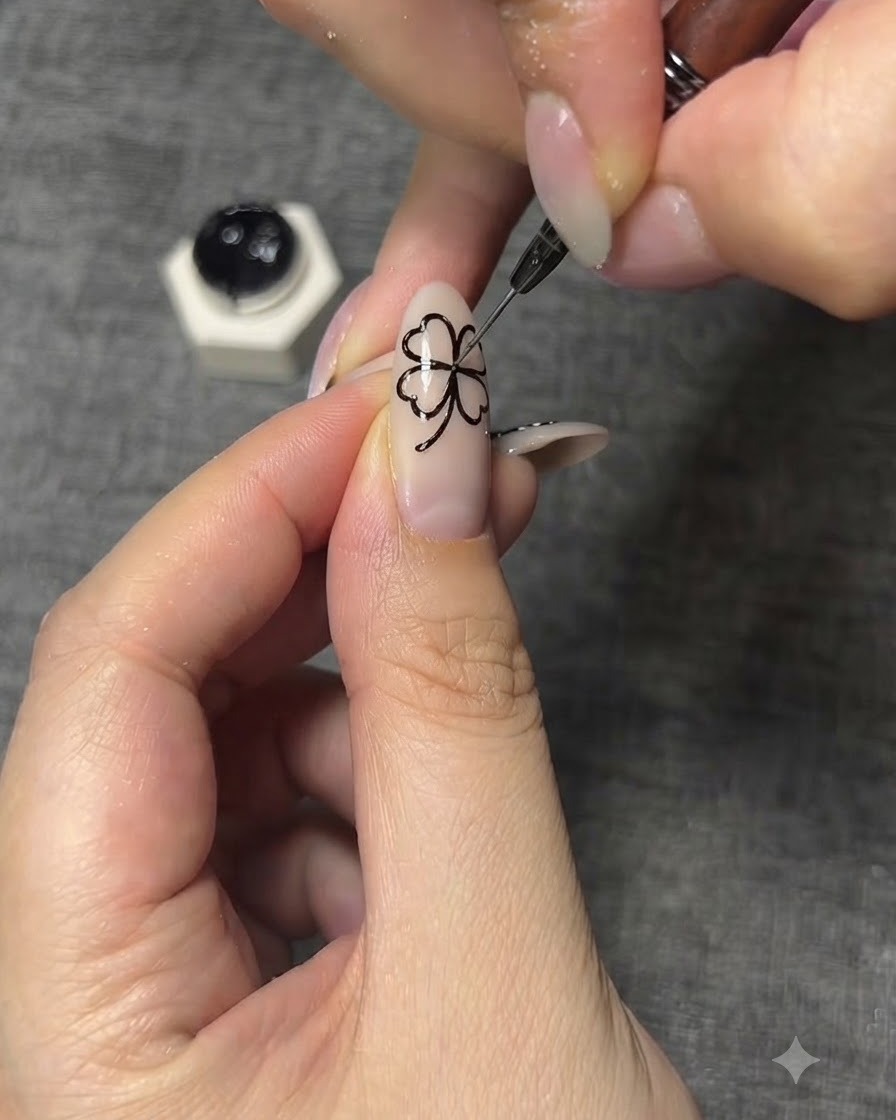 A close-up of a fine nail art brush drawing intricate black vein details onto the butterfly wings.