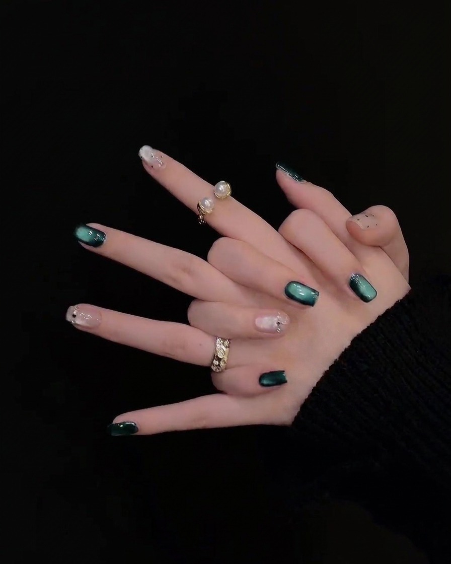 A panning view across the fingers highlighting accent nails decorated with delicate pearls and tiny rhinestones.